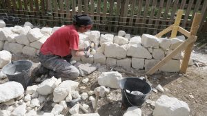 Une participante de l'atelier en train de tailler une pierre de tuffeau